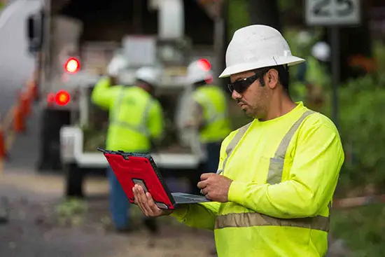 Field professional reviewing a tablet during an on-site assessment